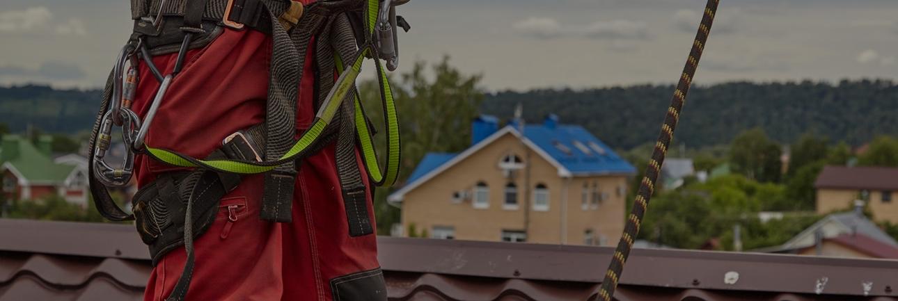 Roofer with fall protection harness